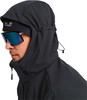 Mann in dunkler Kapuzenjacke und Brille, Kopfdetail.