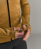Ärmeldetail einer braunen Jacke mit Daumenlöchern und schwarzer Paspel.