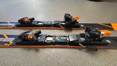 Atomic Redster Skibindung auf Skiern mit orangefarbenen Details.
