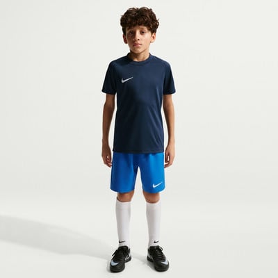Junge in dunkelblauem Nike-T-Shirt und blauen Shorts mit weißen Socken. Junge in dunkelblauem Nike-T-Shirt und blauen Shorts mit weißen Socken.