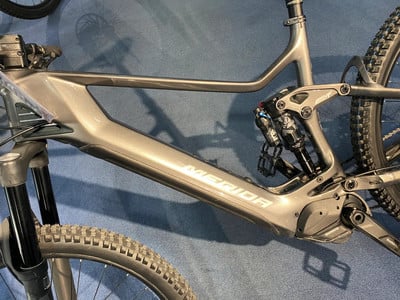 Graues Mountain-E-Bike mit Federung und Merida-Logo. Graues Mountain-E-Bike mit Federung und Merida-Logo.