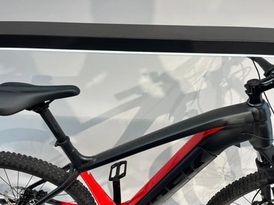 Detail eines elektrischen Mountainbikes mit schwarzem Rahmen und roten Akzenten. Detail eines elektrischen Mountainbikes mit schwarzem Rahmen und roten Akzenten.
