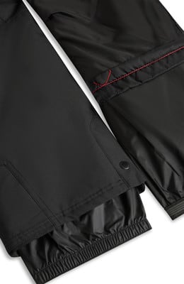 Detail einer schwarzen Hose mit roter Naht und Gummizug.