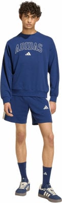 Ein Mann in einem blauen Adidas-Anzug mit Logo auf Sweatshirt und Shorts.