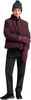 Frau in burgunderroter Jacke, schwarzer Hose und Strickmütze.