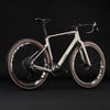 Ein weißes Cube Gravelbike mit braunen Reifen und schwarzen Zipp-Felgen.