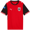 Rotes Fußballtrikot mit schwarzen Ärmeln und Österreich-Logo.