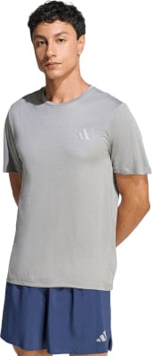 Ein Mann in einem grauen T-Shirt mit Adidas-Logo und dunkelblauen Shorts. Ein Mann in einem grauen T-Shirt mit Adidas-Logo und dunkelblauen Shorts.