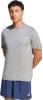 Ein Mann in einem grauen T-Shirt mit Adidas-Logo und dunkelblauen Shorts.