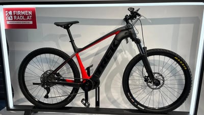 Schwarzes E-Mountainbike der Marke Trek mit roten Rahmenelementen. Schwarzes E-Mountainbike der Marke Trek mit roten Rahmenelementen.