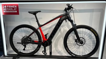 Schwarzes E-Mountainbike der Marke Trek mit roten Rahmenelementen.
