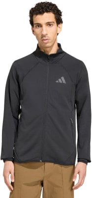 Mann in schwarzer Jacke mit Adidas-Logo und brauner Hose.