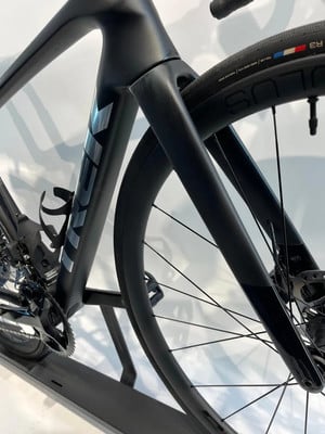 Schwarzer Rennradrahmen mit Trek-Logo und Detail des Vorderrads.