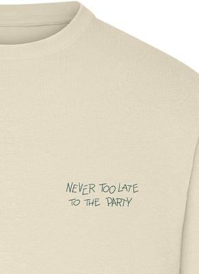 Cremefarbenes T-Shirt mit der Aufschrift „Never too late to the party“. Cremefarbenes T-Shirt mit der Aufschrift „Never too late to the party“.