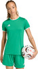 Eine Frau im grünen Fußballtrikot und Shorts hält einen Fußball.