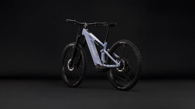 Ein hellviolettes vollgefedertes E-Bike vor schwarzem Hintergrund. Ein hellviolettes vollgefedertes E-Bike vor schwarzem Hintergrund.