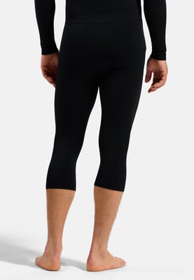 Ein Mann in schwarzen Dreiviertel-Leggings und langärmeligem Oberteil, von hinten gesehen. Ein Mann in schwarzen Dreiviertel-Leggings und langärmeligem Oberteil, von hinten gesehen.
