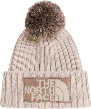 Eine beige Strickmütze mit Bommel und The North Face Logo.
