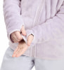 Ein Mädchen passt den Ärmel einer hellvioletten Fleecejacke mit Daumenöffnungen an.