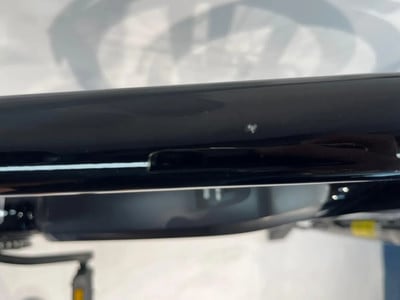 Detail eines schwarzen Fahrradrahmens mit kleiner Lackbeschädigung. Detail eines schwarzen Fahrradrahmens mit kleiner Lackbeschädigung.