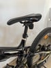 Detail eines Mountainbikes mit Dämpfer und Sattelstütze.