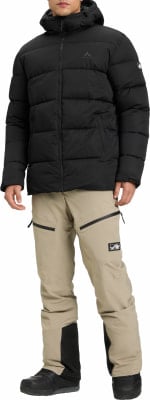 Mann in schwarzer Daunenjacke und beiger Hose mit Berglöwen-Logo. Mann in schwarzer Daunenjacke und beiger Hose mit Berglöwen-Logo.