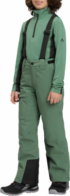 Mädchen in grüner Skijacke mit schwarzem Hosenträger und Hose. Mädchen in grüner Skijacke mit schwarzem Hosenträger und Hose.