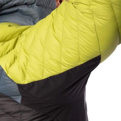 Detail einer Daunenjacke mit gestepptem grünem Ärmel und schwarzem Stoff. Detail einer Daunenjacke mit gestepptem grünem Ärmel und schwarzem Stoff.