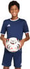 Ein Junge im dunkelblauen Fußballtrikot und Shorts hält einen Ball.