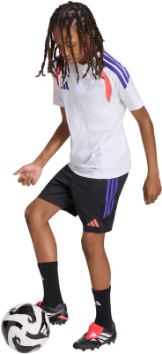 Junge im weißen Trikot und schwarzer Hose mit Fußball. Junge im weißen Trikot und schwarzer Hose mit Fußball.