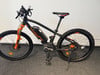Schwarzes E-Bike mit orangefarbenen Details und Intersport-Aufschrift auf dem Rahmen.