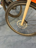 Detail eines Fahrrad-Vorderrads mit Scheibenbremse auf blauem Teppich.