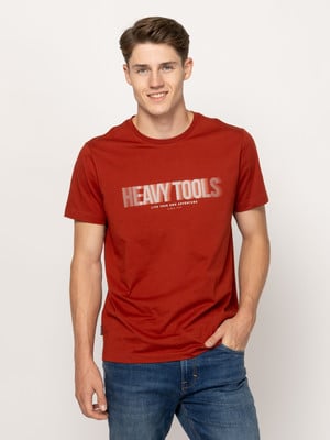Egy férfi piros pólóban felirattal és farmerban áll fehér háttér előtt. Egy férfi piros pólóban felirattal és farmerban áll fehér háttér előtt.