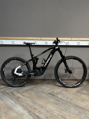 Ein schwarzes Haibike E-Bike mit Federung auf Holzboden. Ein schwarzes Haibike E-Bike mit Federung auf Holzboden.