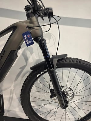 Vorderansicht eines Mountain-E-Bikes mit Federung und Anhänger. Vorderansicht eines Mountain-E-Bikes mit Federung und Anhänger.