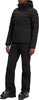 Schwarze Daunenjacke mit Kapuze und Skihose mit Skischuhen.