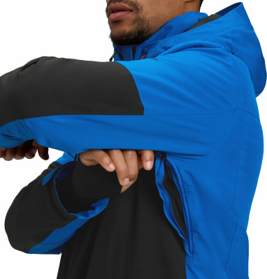 Ein Mann in einer blauen Jacke mit schwarzen Ärmeln schließt den Reißverschluss. Ein Mann in einer blauen Jacke mit schwarzen Ärmeln schließt den Reißverschluss.