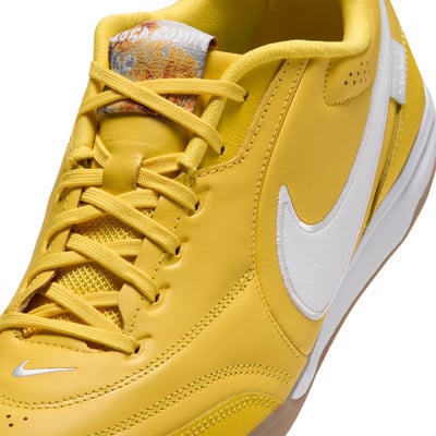 Detail eines gelben Nike-Schuhs mit weißem Logo und Schnürsenkeln.