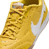 Detail eines gelben Nike-Schuhs mit weißem Logo und Schnürsenkeln.