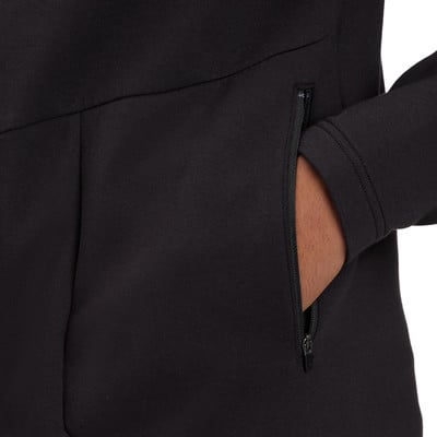 Detail černé mikiny s kapsou na zip, kam si někdo dává ruku. Detail černé mikiny s kapsou na zip, kam si někdo dává ruku.
