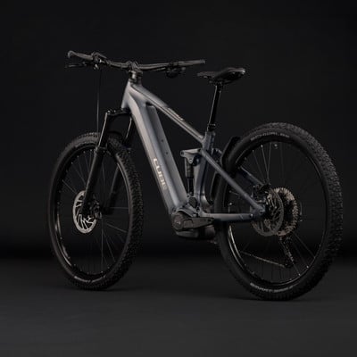 Graues Fullsuspension E-Bike von Cube mit schwarzen Rädern und Federung. Graues Fullsuspension E-Bike von Cube mit schwarzen Rädern und Federung.
