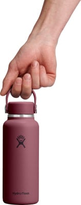 Eine Hand hält eine weinrote Hydro Flask Flasche am Griff. Eine Hand hält eine weinrote Hydro Flask Flasche am Griff.