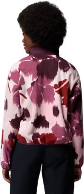 Frau in einem rosa Fleece-Pullover mit Blumenmuster und schwarzen Hosen. Frau in einem rosa Fleece-Pullover mit Blumenmuster und schwarzen Hosen.