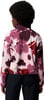 Frau in einem rosa Fleece-Pullover mit Blumenmuster und schwarzen Hosen.
