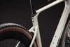 Nahaufnahme eines Fahrradrahmens in Beige mit schwarzer Sattelstütze.