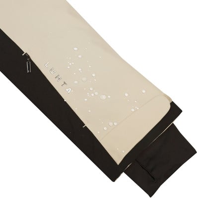 Beiger Stoff mit Wassertropfen und Luhta-Logo, dunkler Saum. Beiger Stoff mit Wassertropfen und Luhta-Logo, dunkler Saum.