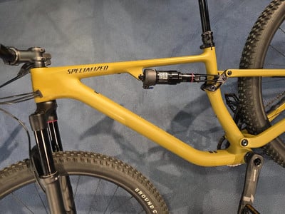 Ein gelbes Mountainbike mit Federung und schwarzen Rädern auf blauem Hintergrund. Ein gelbes Mountainbike mit Federung und schwarzen Rädern auf blauem Hintergrund.