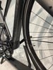 Detail eines E-Bikes mit Antrieb und Kette auf einem Ständer.