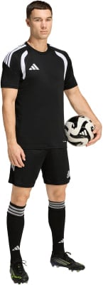 Ein Mann im schwarzen Fußballtrikot und Shorts hält einen Ball. Ein Mann im schwarzen Fußballtrikot und Shorts hält einen Ball.