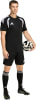 Ein Mann im schwarzen Fußballtrikot und Shorts hält einen Ball.
